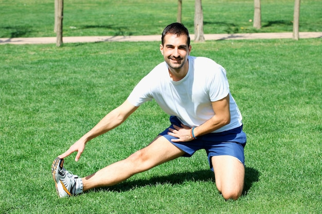 A man engaged in exercise outdoors in an open garden. He is shown performing physical activities that promote healthy bones and overall fitness. The man is dressed in appropriate workout attire and is actively involved in his exercise routine.