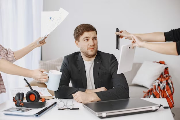 A young man, a solopreneur, is depicted with an astonished expression on his face. Surrounding him are multiple hands holding various documents, representing the constant thoughts of comparison and self-doubt that he experiences.