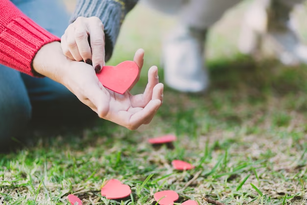 A heartwarming moment captured where a girl is placing a card of hearts into someone's hand. The girl is holding a colorful card adorned with hearts and is gently extending her hand towards the viewer or another person off-screen. Sharing love is also a kind of meditation,